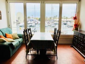 a table and chairs in a living room with a view of a harbor at NAUTICA 2 E in Empuriabrava