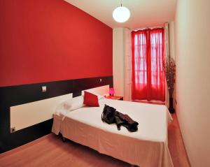 Łóżko lub łóżka w pokoju w obiekcie Apartamentos El Tiempo Madrid