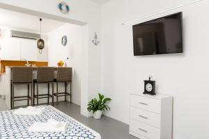 een witte woonkamer met een flatscreen-tv aan de muur bij Studio apartment Sesula in Split