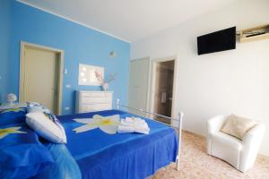 a blue bedroom with a bed and a chair at La Fenice Salentina in Alezio