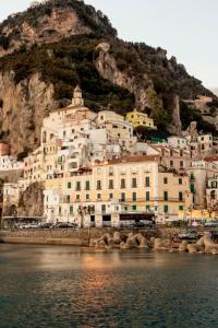 a group of buildings on a hill next to the water at Dimore De Luca in Amalfi