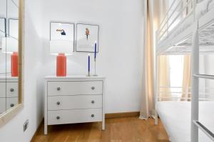 een slaapkamer met een wit dressoir en een bed bij Gran Vía - Tu Apartamento Ideal para Disfrutar Madrid al Máximo in Madrid