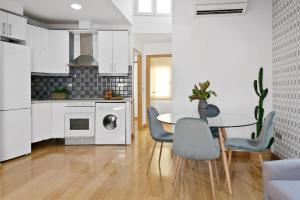 een keuken met een tafel en stoelen in een kamer bij Gran Vía - Tu Apartamento Ideal para Disfrutar Madrid al Máximo in Madrid +62 foto's