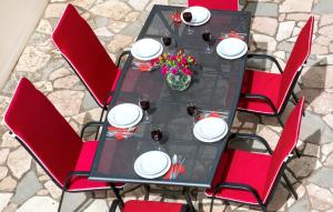 a table with red chairs and white plates and flowers at Apartmani AMI in Podstrana