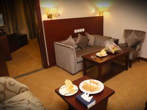 a living room with a couch and two tables at Al Aqeeq Al Rawda Hotel by Abu Al Joud in Al Madinah +32 photos