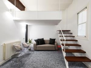 a living room with a staircase and a couch at Fewdays Barcelona Apartments in Barcelona