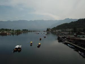 a group of boats in a river with mountains at Lake Palace Group Of House Boats in Srinagar