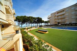 an apartment with a lawn next to a swimming pool at Cala Gonzalez Superior Orange Costa in Alcossebre