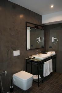 a bathroom with a sink and a toilet and a mirror at Prime Hotel in Tirana +37 photos