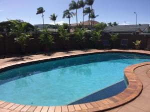 a large swimming pool in a yard with palm trees at 2BD Family or Couple Guesthouse Upstairs near Turf club, HOTA in Bundall in Gold Coast