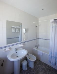 La salle de bains est pourvue d'un lavabo, de toilettes et d'une baignoire. dans l'établissement Hotel Las Terrazas, à Albolote
