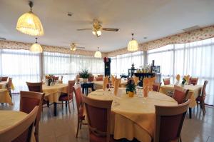 a dining room with tables and chairs and windows at Ai Campi Di Marcello Hotel in Monfalcone