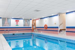een groot zwembad in een fitnessruimte met bij Macdonald Lochanhully Resort in Carrbridge
