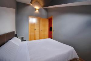 Łóżko lub łóżka w pokoju w obiekcie Apartamentos El Tiempo Madrid