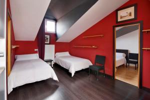 a red room with two beds and a mirror at Apartamentos El Tiempo in Madrid