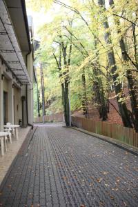 a brick walkway with benches on the side of a building at hostel leśny in Sopot