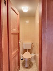 a small bathroom with a toilet and a door at Apartment Jacky 7 in Verbier