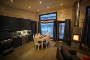 a kitchen and dining room with a table and a fireplace at Lomat&auml;rppi in Utsjoki