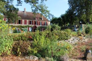 una casa antigua con un jardín delante de ella en Les Indrins en Marzy