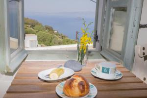 einen Tisch mit Brotplatten und einer Tasse Kaffee in der Unterkunft Pyrgos Stone House in Emporeiós