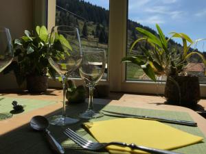 a table with two wine glasses on a table at Chez Jeanmyvonne in La Bresse