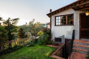 a house with a fence next to a yard at Santa Lucia Suite Camaiore in Santa Lucia