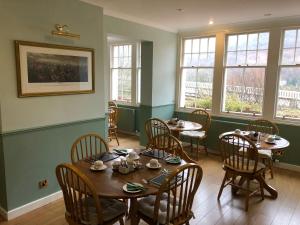 una sala da pranzo con tavoli, sedie e finestre di Tigh na Cheo a Kinlochleven