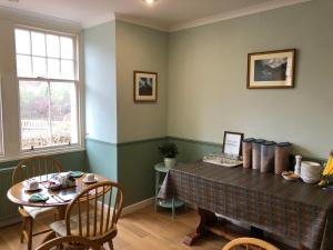 a dining room with a table and chairs and a window at Tigh na Cheo in Kinlochleven