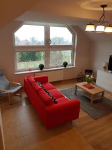 salon z czerwoną kanapą i dwoma oknami w obiekcie Apartment Karpacz w mieście Karpacz