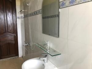 une salle de bain avec un lavabo, un miroir et une douche dans l'établissement Khách sạn Đồng Dao, à Hue