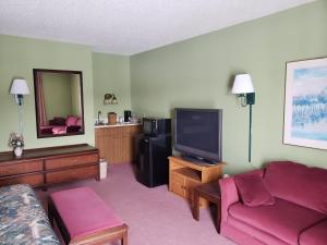 a living room with a couch and a tv at Harbor Lights Lodge in Kewaunee