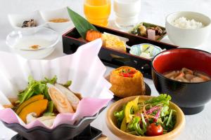 uma bandeja de comida com tigelas de comida numa mesa em Yatsugatake Grace Hotel em Minamimaki