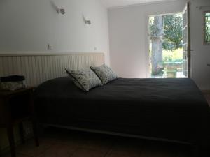 a bedroom with a bed with two pillows on it at Chambres d'hôtes de la gardy in Eyragues