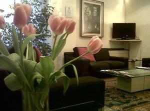 a vase with pink flowers in a living room at Hotel Giovanni in Padova