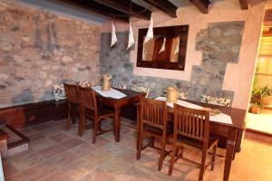 a dining room with a wooden table and chairs at El Pedrís in El Pont de Suert