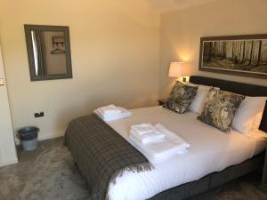 1 dormitorio con 1 cama con 2 toallas en Camerton Inn Cottage en Bath