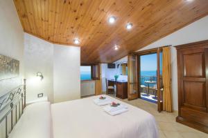 sypialnia z białym łóżkiem i drewnianym sufitem w obiekcie B&B Il Nespolo w mieście Furore