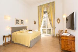 Schlafzimmer mit einem Bett, einem TV und einem Fenster in der Unterkunft Prestigious Apartment via Barberini in Rom