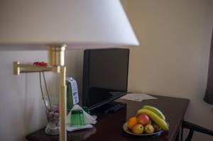 a desk with a lamp and a bowl of fruit on it at Hotel U Salzmannů in Pilsen
