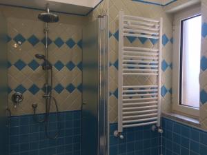 uma casa de banho com um chuveiro com azulejos azuis em Albergo Oasi em Nápoles
