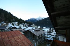 a view of a town with snow covered buildings and mountains at Casa Katia in Canale dʼAgordo