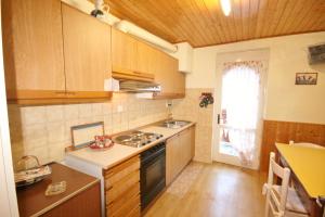 a kitchen with wooden cabinets and a stove top oven at Casa Katia in Canale dʼAgordo