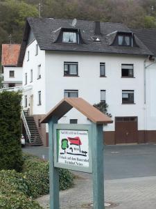 een bord voor een huis met een gebouw bij Gästehaus Neises in Minden