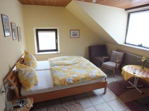 ein Schlafzimmer mit einem Bett und einem Stuhl in einem Zimmer in der Unterkunft Gästehaus Neises in Minden