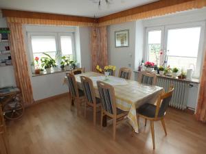 a dining room with a table and chairs and windows at Gästehaus Neises in Minden