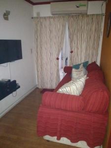 sala de estar con sofá rojo y ventana en Apartamento Baykus en Córdoba