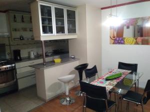 cocina con mesa de cristal y sillas en Apartamento Baykus en Córdoba