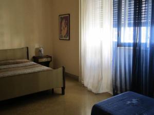 a bedroom with a bed and a window with curtains at Da Mary Guest House in Palermo