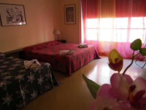 a room with a bed, a table and a vase of flowers at Da Mary Guest House in Palermo