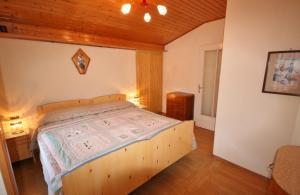 a bedroom with a wooden bed in a room at Casa Katia in Canale dʼAgordo